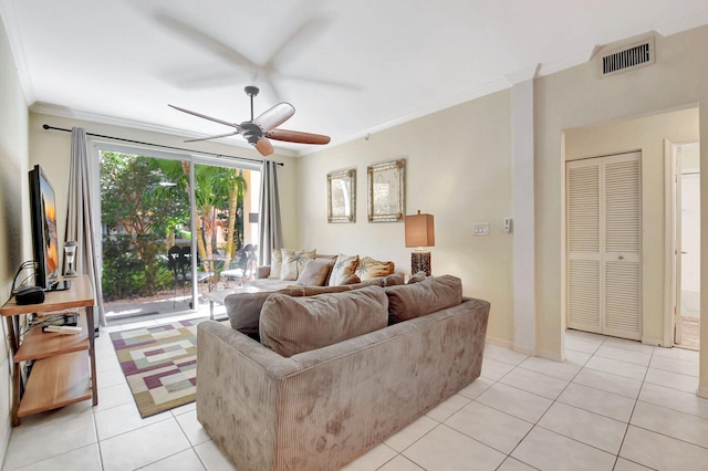 living area with light tile patterned floors, visible vents, baseboards, a ceiling fan, and crown molding