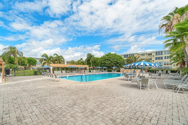 community pool with fence and a patio