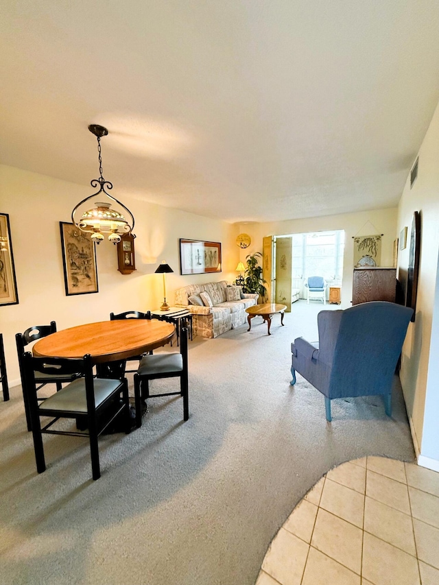 dining room with light tile patterned floors, visible vents, and light colored carpet