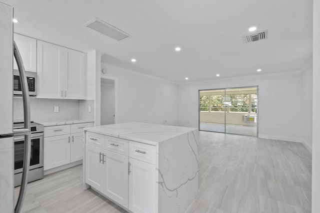 kitchen featuring electric stove, ornamental molding, tasteful backsplash, white cabinets, and light stone countertops