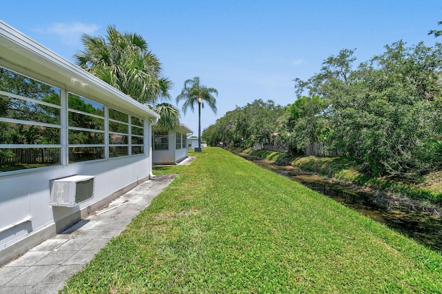 view of grassy yard with a wall mounted AC