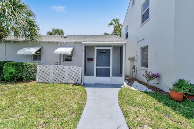 view of front facade with a front yard and stucco siding