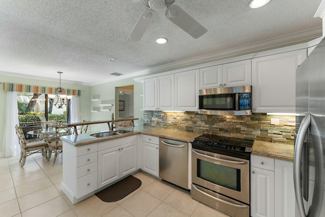 kitchen with appliances with stainless steel finishes, white cabinetry, a peninsula, and a sink