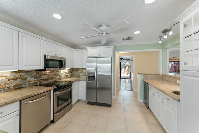 kitchen featuring light tile patterned flooring, decorative backsplash, appliances with stainless steel finishes, and white cabinetry