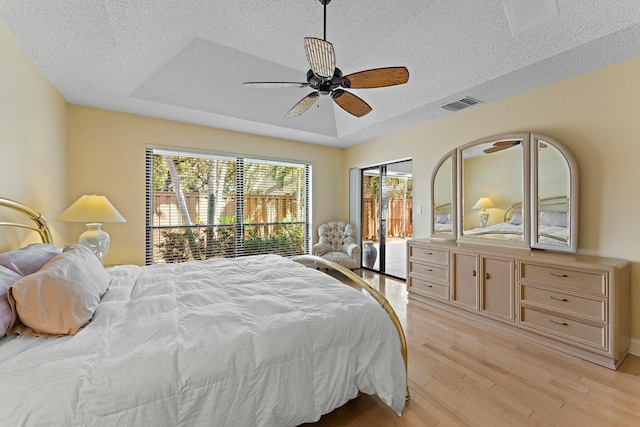 bedroom with light wood-type flooring, visible vents, multiple windows, and access to exterior