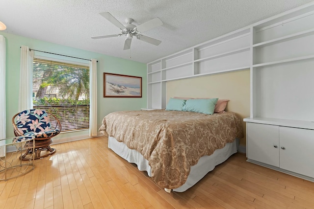 bedroom featuring light wood-type flooring, a textured ceiling, and ceiling fan