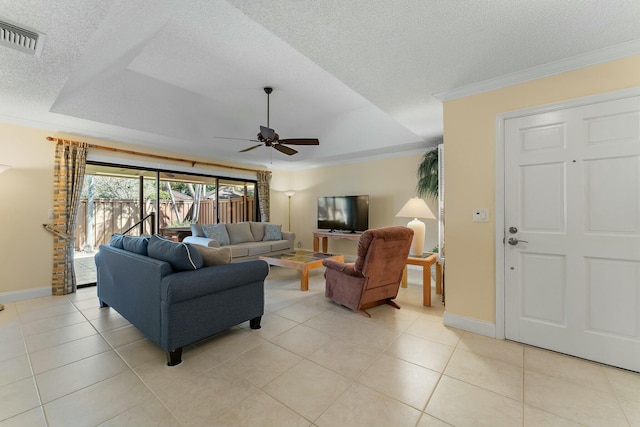 living area with visible vents, ornamental molding, a textured ceiling, light tile patterned floors, and a raised ceiling