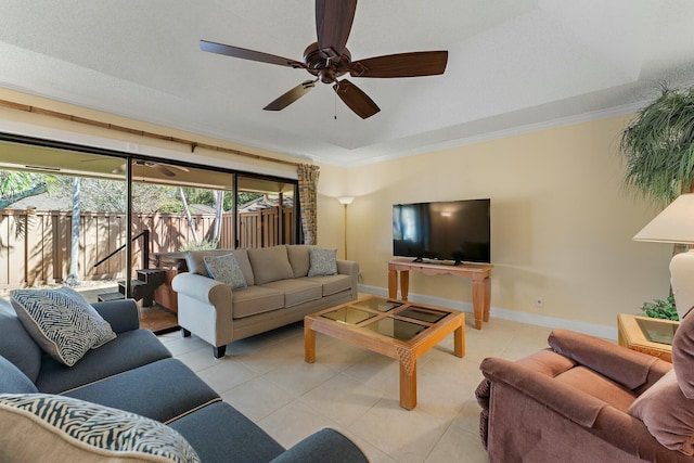 living room with light tile patterned floors, a ceiling fan, crown molding, and baseboards