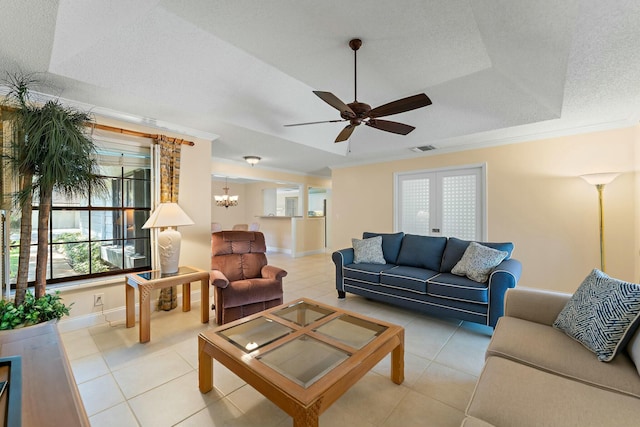 living area featuring light tile patterned floors, visible vents, a textured ceiling, and ornamental molding