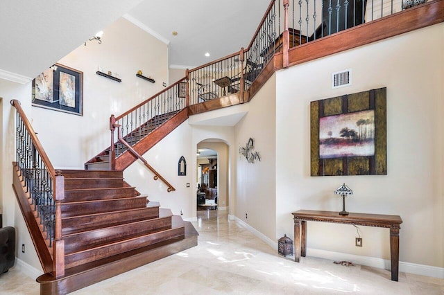 stairs featuring visible vents, a towering ceiling, and baseboards