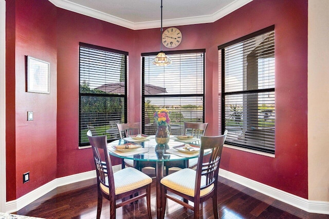 dining space featuring baseboards, ornamental molding, and wood finished floors