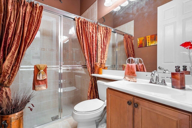 bathroom featuring toilet, a shower stall, and vanity