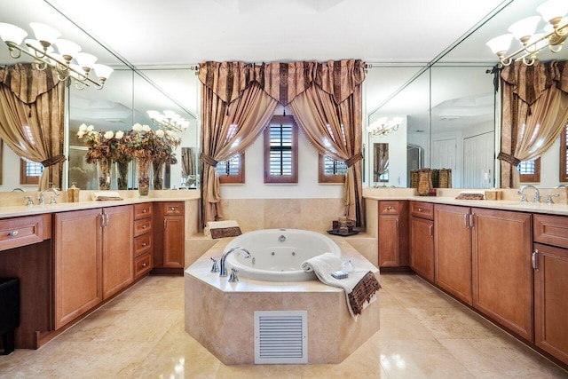 full bathroom with two vanities, a notable chandelier, and a jetted tub