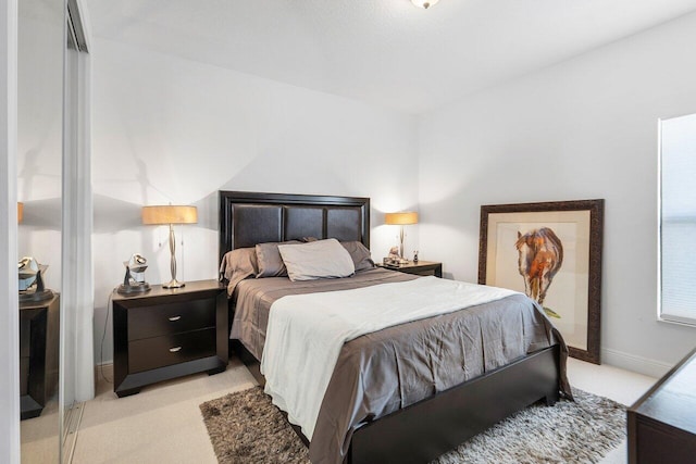 bedroom featuring light carpet and baseboards