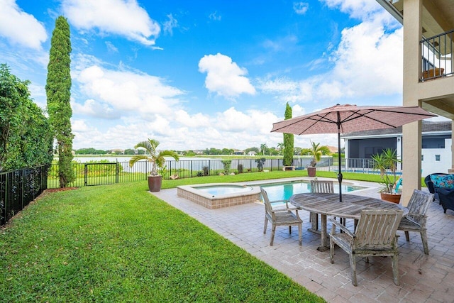 view of yard with a water view, a fenced backyard, a pool with connected hot tub, and a patio