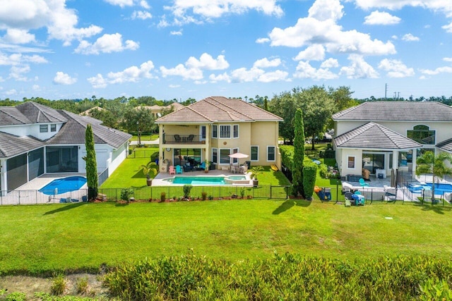 rear view of property with a patio, a fenced backyard, a balcony, a pool with connected hot tub, and a yard