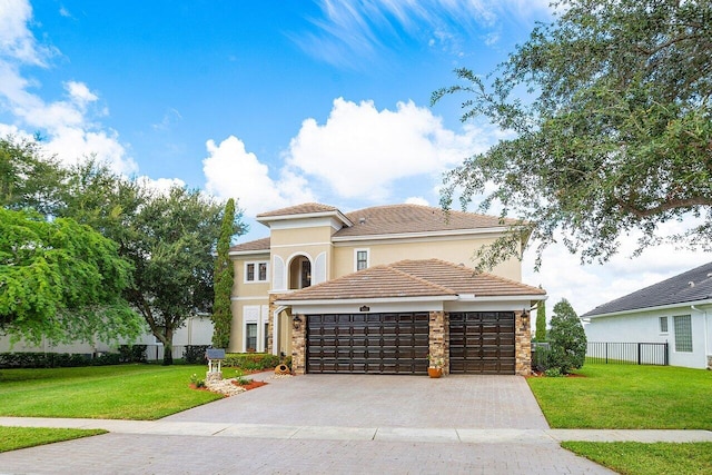 mediterranean / spanish-style home with a front yard, driveway, an attached garage, and fence