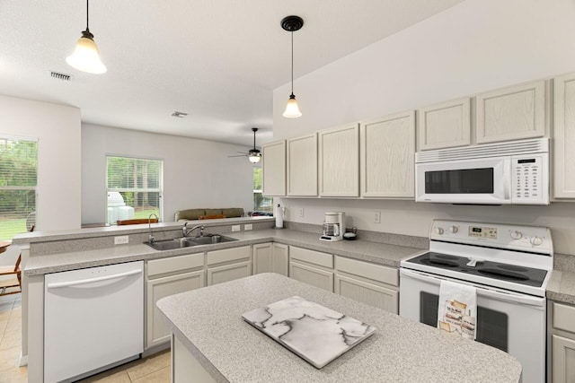 10617 Pine Cone Ln, Fort Pierce, FL 34945 - kitchen with white appliances, light countertops, a sink, and a peninsula