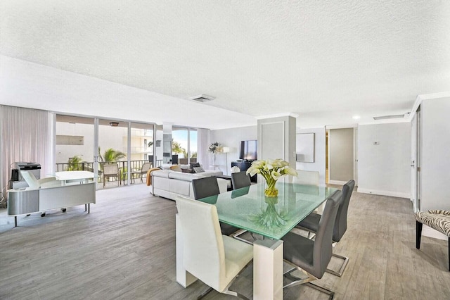 dining area featuring a textured ceiling, visible vents, and wood finished floors