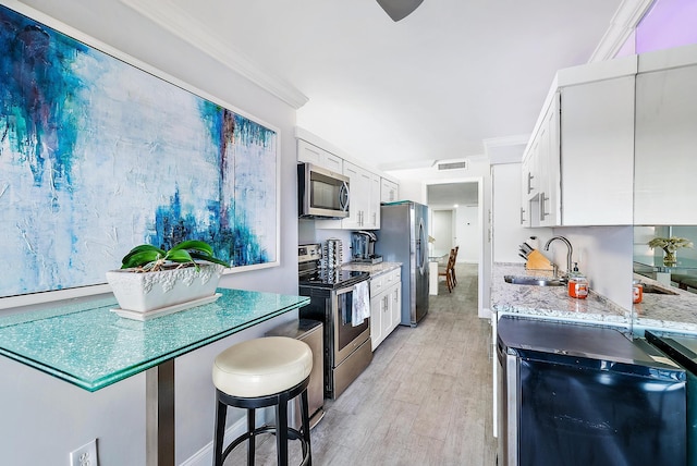 kitchen with a sink, white cabinetry, visible vents, appliances with stainless steel finishes, and crown molding