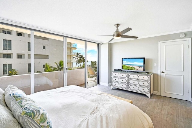 bedroom with ceiling fan, wood finished floors, baseboards, access to outside, and ornamental molding