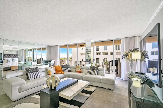 living area featuring a wall of windows, ornamental molding, a textured ceiling, and wood finished floors