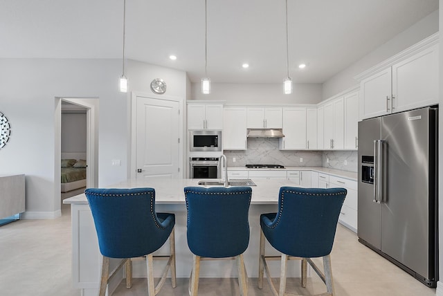 kitchen with white cabinets, appliances with stainless steel finishes, backsplash, under cabinet range hood, and a sink