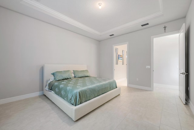 bedroom with baseboards, visible vents, a tray ceiling, and crown molding