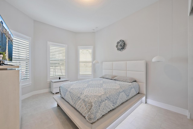 bedroom featuring light tile patterned floors and baseboards