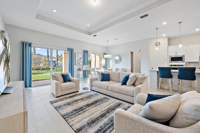 living area with a tray ceiling, visible vents, recessed lighting, and light tile patterned flooring