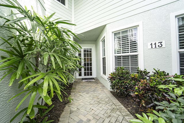 entrance to property featuring stucco siding