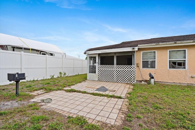 314 SW Cherry Hill Rd, Port Saint Lucie, FL 34953 - rear view of property with fence, a sunroom, a yard, stucco siding, and a patio area