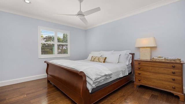 bedroom featuring dark wood-style floors, crown molding, baseboards, and a ceiling fan