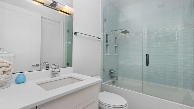 bathroom featuring toilet, shower / bath combination with glass door, and vanity