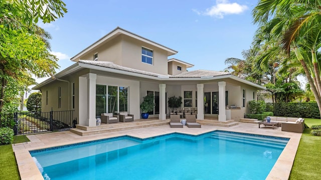 back of house with outdoor lounge area, fence, a fenced in pool, stucco siding, and a patio area