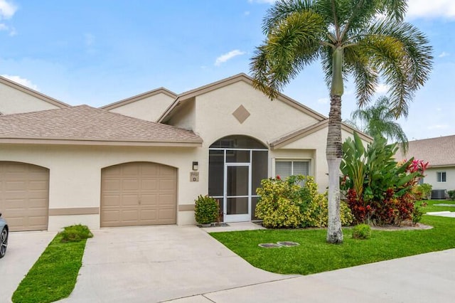 view of front of property with an attached garage, a front yard, concrete driveway, and stucco siding