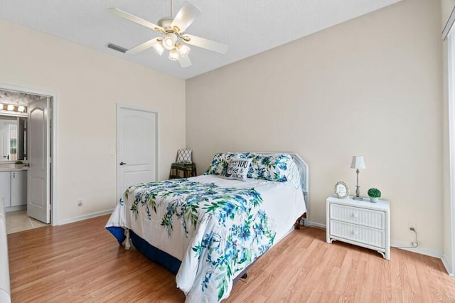 bedroom with ceiling fan, wood finished floors, connected bathroom, and baseboards