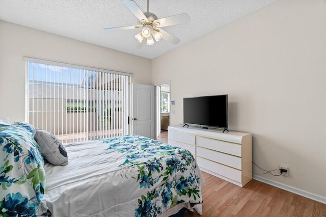 bedroom featuring light wood finished floors, access to outside, a ceiling fan, and a textured ceiling