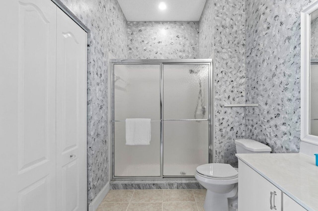 full bath with wallpapered walls, a stall shower, toilet, tile patterned floors, and vanity