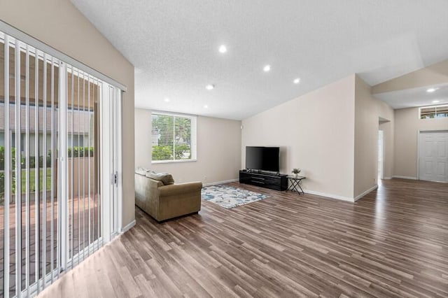 unfurnished living room featuring a textured ceiling, recessed lighting, wood finished floors, and baseboards