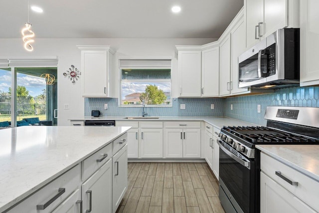 kitchen featuring white cabinets, a wealth of natural light, stainless steel appliances, and a sink