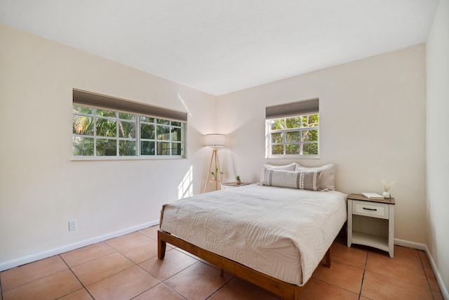 bedroom with tile patterned flooring and baseboards