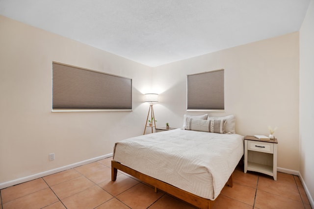 bedroom featuring tile patterned flooring and baseboards