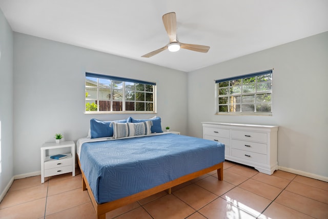 bedroom featuring multiple windows, baseboards, and light tile patterned flooring