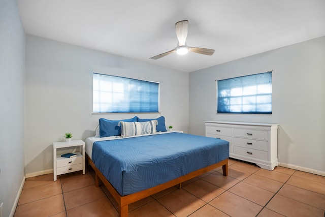 bedroom featuring light tile patterned floors, multiple windows, and baseboards