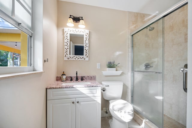 bathroom featuring a stall shower, vanity, and toilet