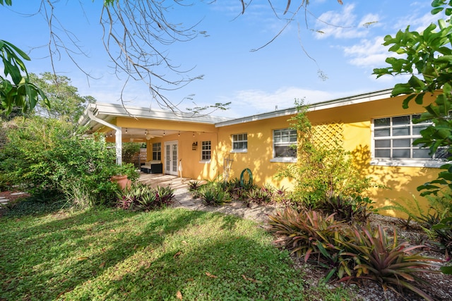 back of property with french doors, a patio area, and stucco siding