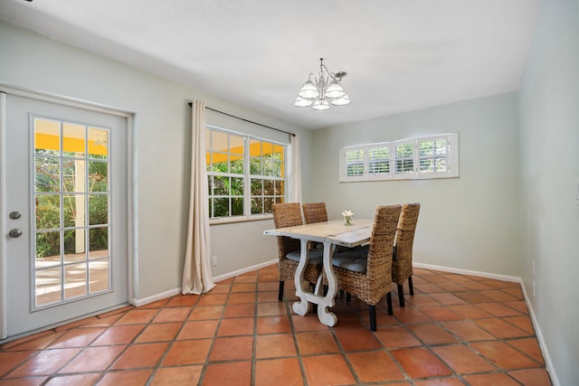 tiled dining area with a chandelier, plenty of natural light, and baseboards