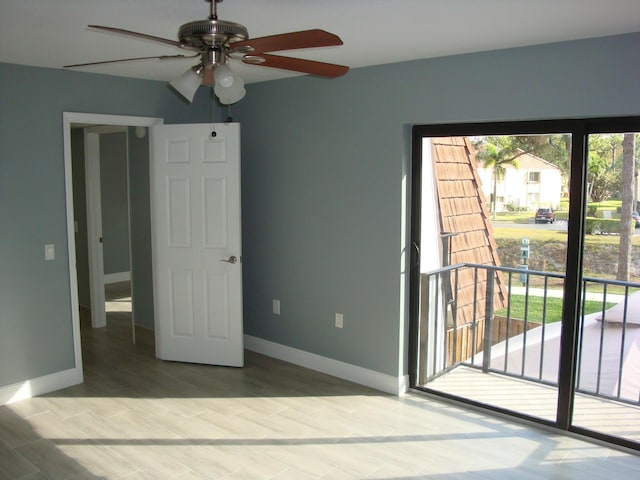 unfurnished bedroom featuring access to outside, baseboards, a ceiling fan, and wood finished floors