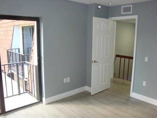 empty room with visible vents, baseboards, and wood finished floors